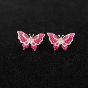 Pink butterfly earrings on black background